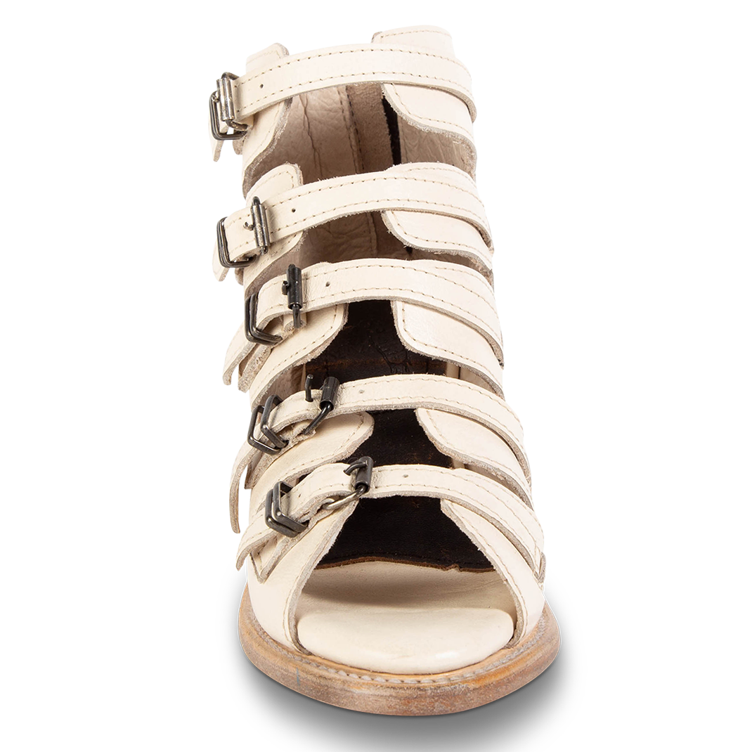 Front view showing buckle cut outs and leather straps on FREEBIRD women's Quinn beige sandal