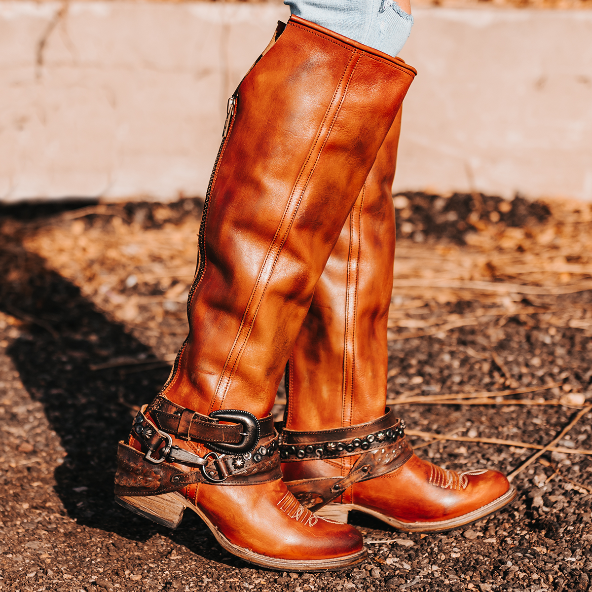FREEBIRD women's Rodondo whiskey boot featuring a a relaxed silhouette, low heel, and mixed metal buckles