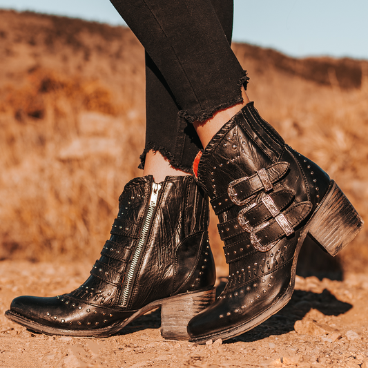 FREEBIRD women's Savanna black leather ankle bootie with silver studs, elastic gore, and metal buckles
