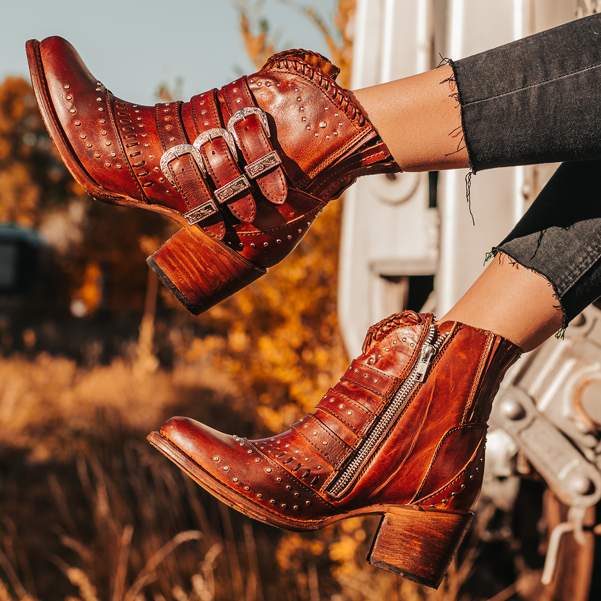 FREEBIRD women's Savanna cognac leather ankle bootie with silver studs, elastic gore, and metal buckles