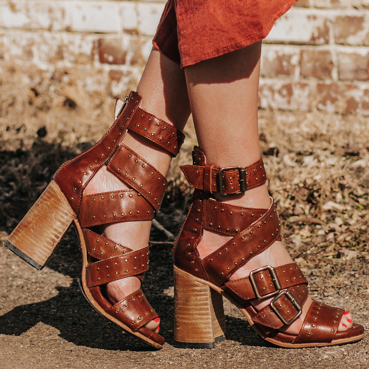 FREEBIRD women's Tanica cognac a strappy heeled sandal featuring buckle and stud detailing and working back zip closure
