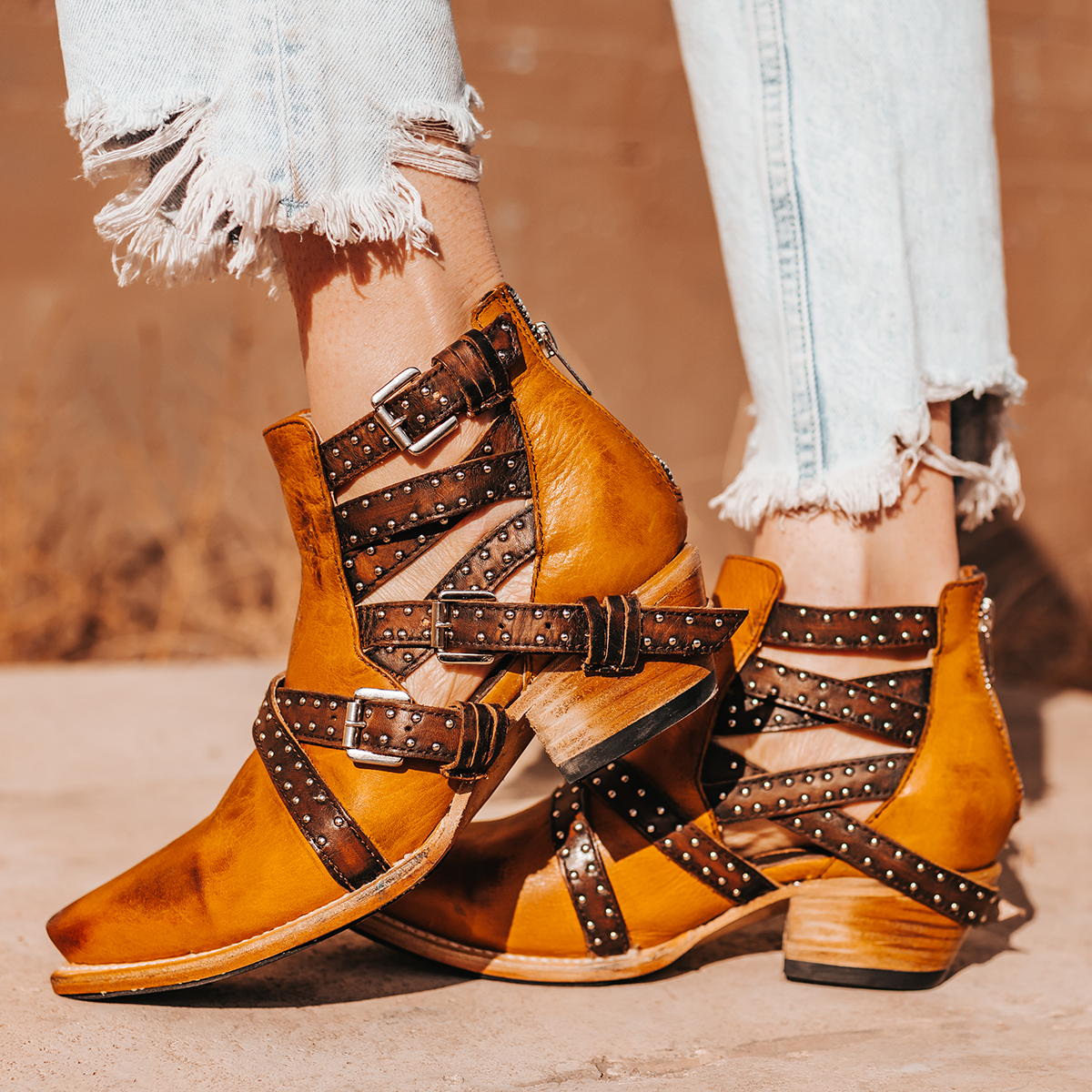 FREEBIRD women's Wasp wheat ankle bootie with exposed sides, adjustable fastener metal buckles, working back zip closure, snip toe, and traditional snip toe
