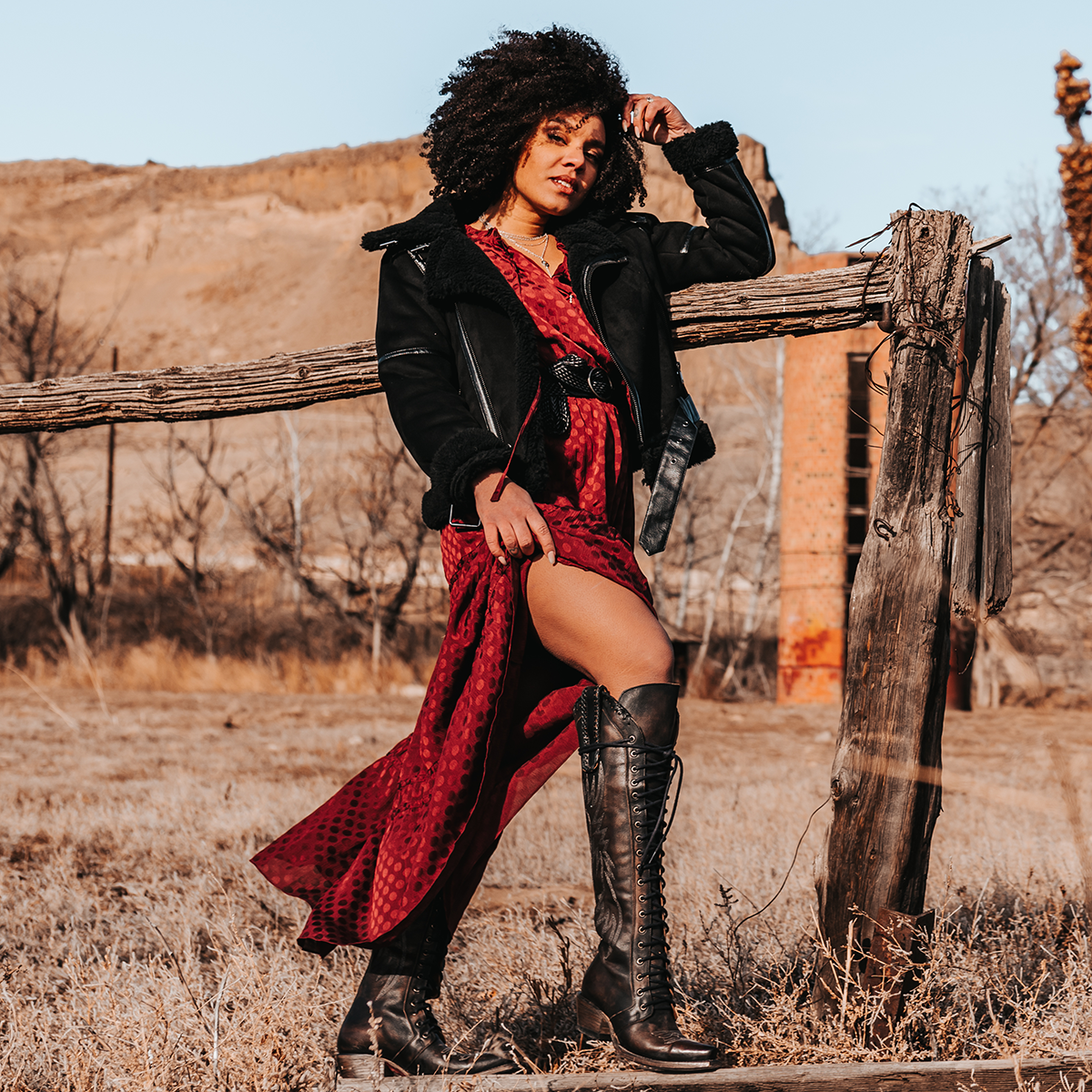 FREEBIRD women's Wilder black boot featuring a tall lace up shaft, contrasting stitch detailing, woven leather accents, and a back brass zip closure lifestyle