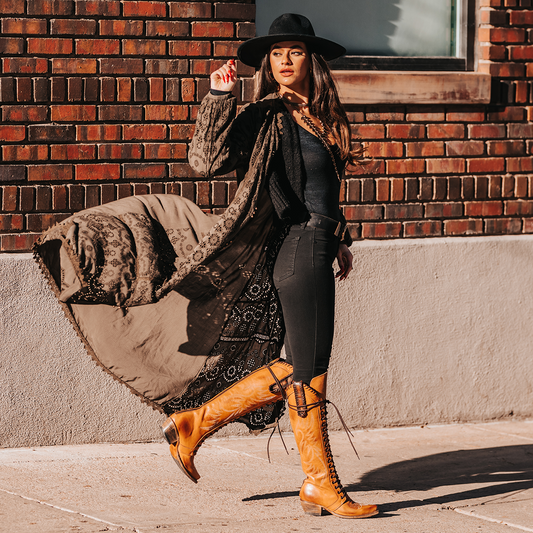FREEBIRD women's Wilder wheat boot featuring a tall lace up shaft, contrasting stitch detailing, woven leather accents, and a back brass zip closure lifestyle