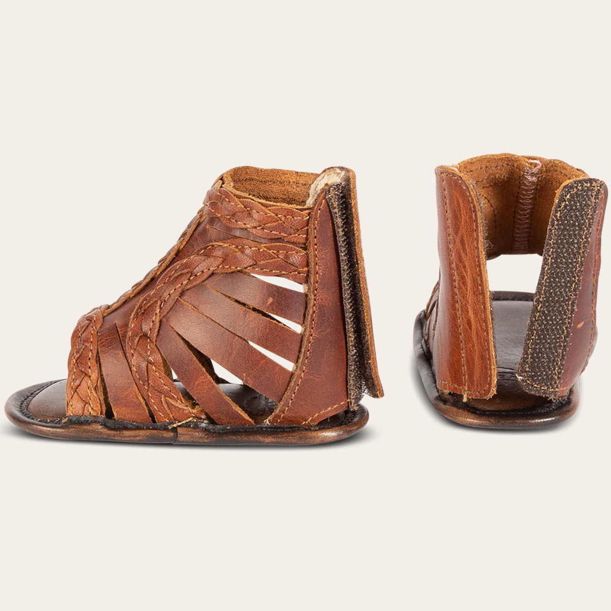 side and back view showing laser-cut leather, braided accents and leather back velcro panel on FREEBIRD infant baby bela cognac leather sandal