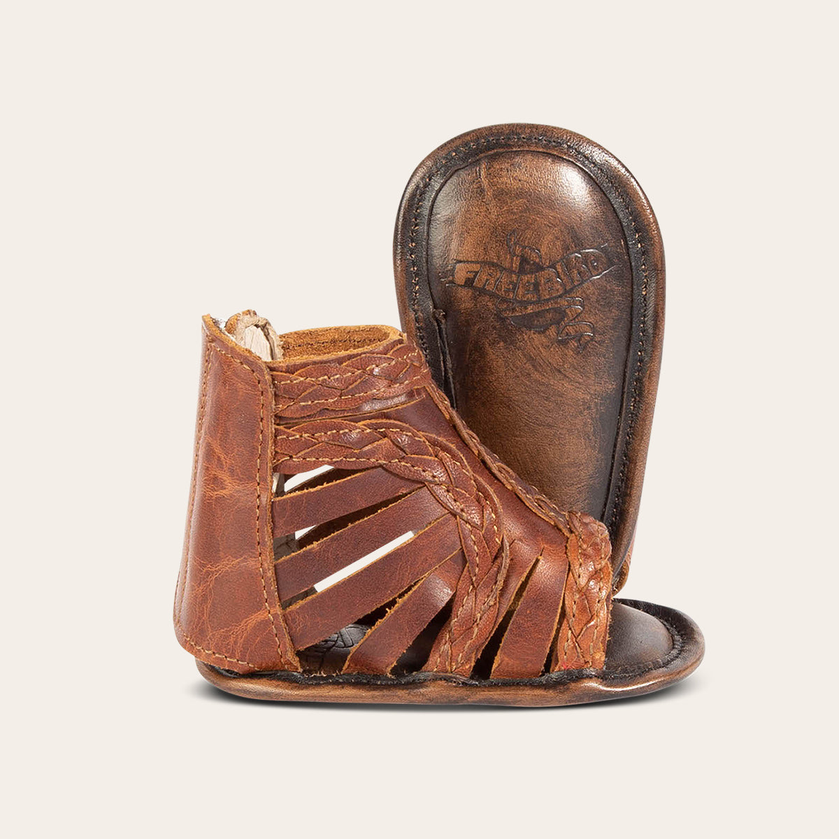 Front view showing laser-cut leather, braided accents and soft leather imprinted sole on FREEBIRD infant baby bela cognac leather sandal
