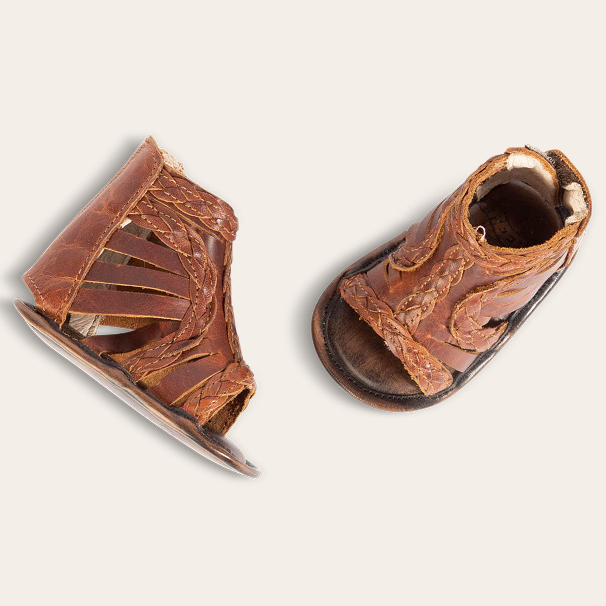 top view showing laser-cut leather and braided accents on FREEBIRD infant baby bela cognac leather sandal