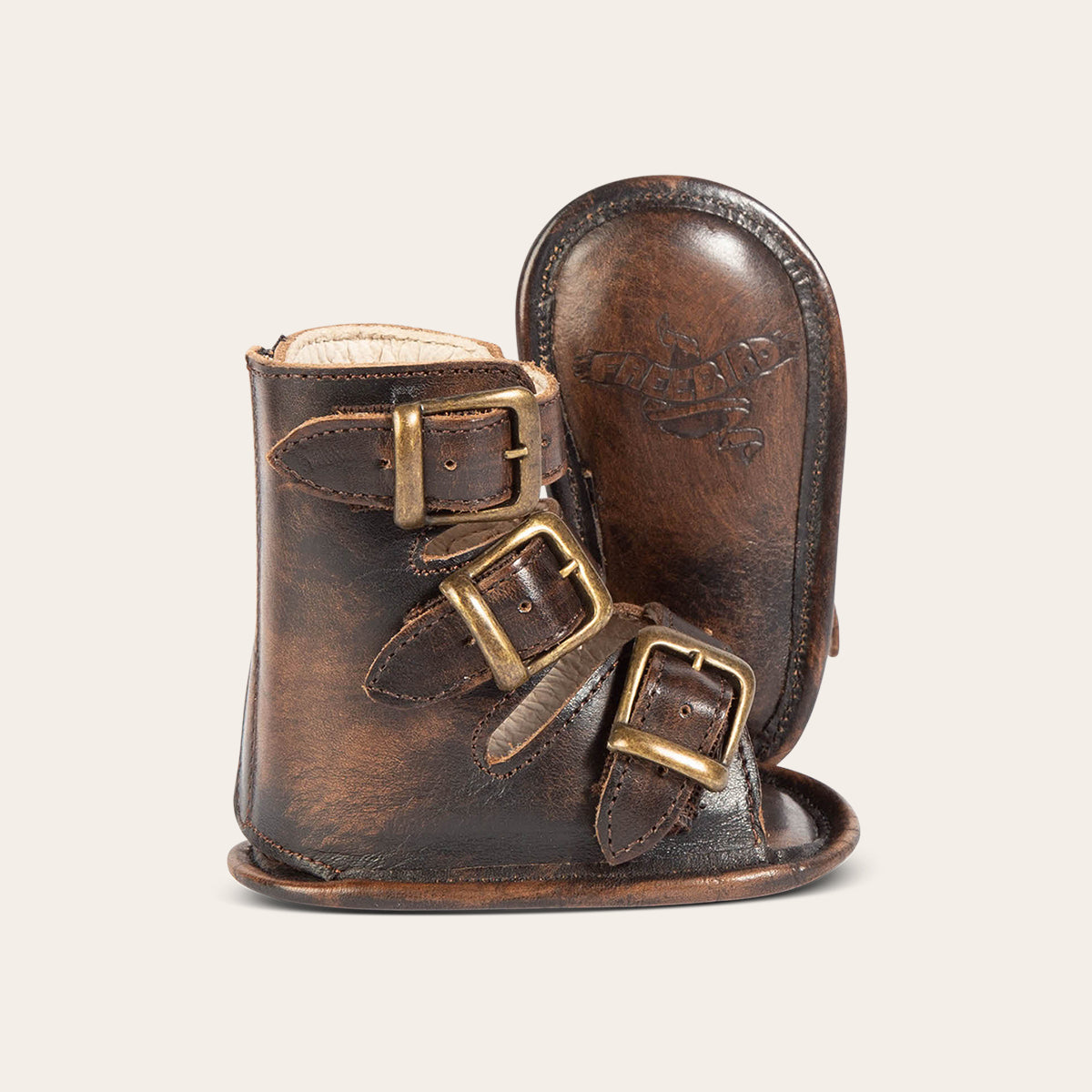 side view showing buckle fashion straps and soft leather imprinted sole on FREEBIRD infant baby bond black sandal