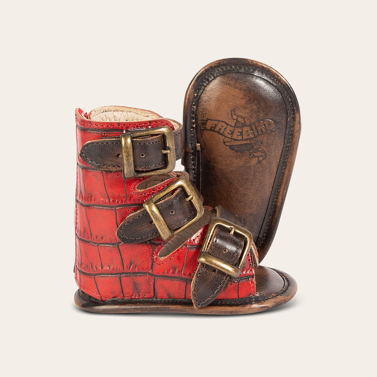 side view showing buckle fashion straps and soft leather imprinted sole on FREEBIRD infant baby bond red croco sandal 
