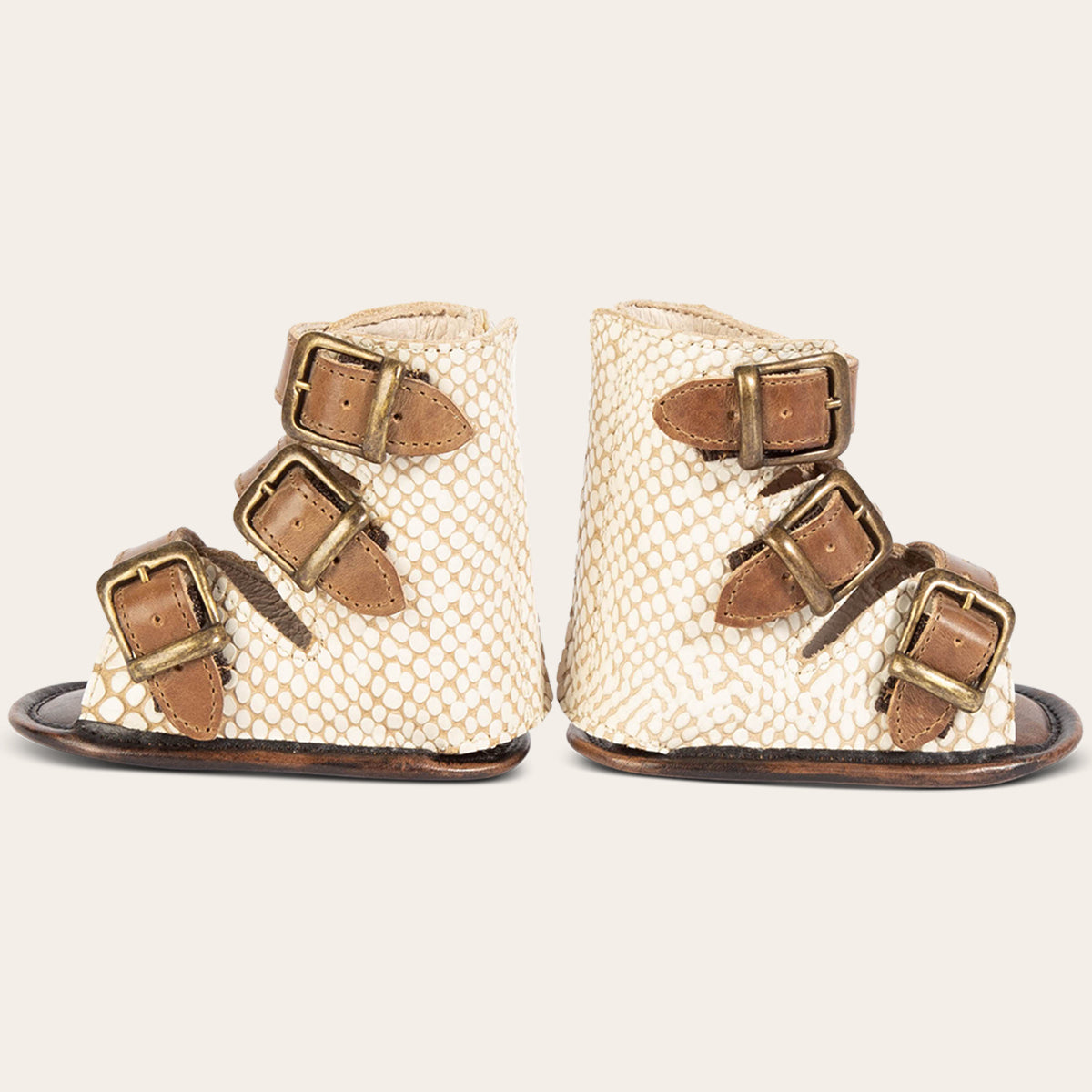 side view showing buckle fashion straps on FREEBIRD infant baby bond white snake sandal