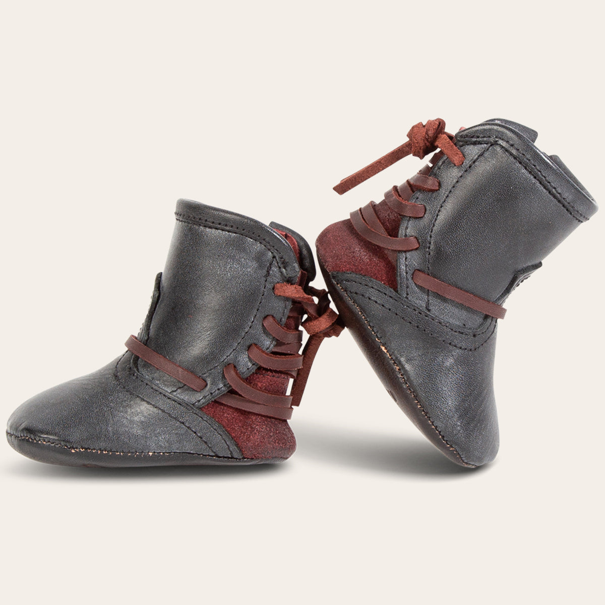 side view showing contrasting back lace detailing on FREEBIRD infant baby coal black leather bootie