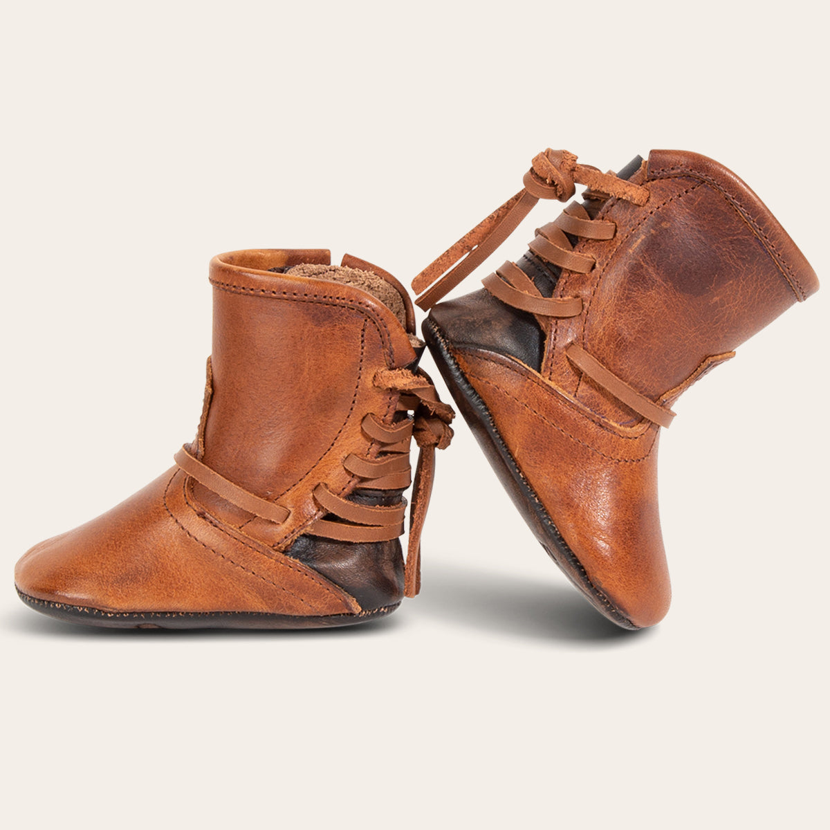 side view showing back lace detailing on FREEBIRD infant baby coal cognac leather bootie