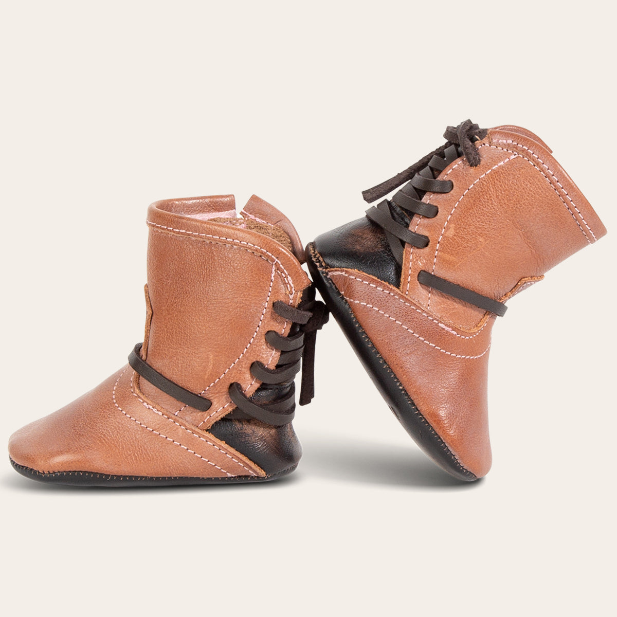side view showing contrasting back lace detailing on FREEBIRD infant baby coal dusty rose leather bootie