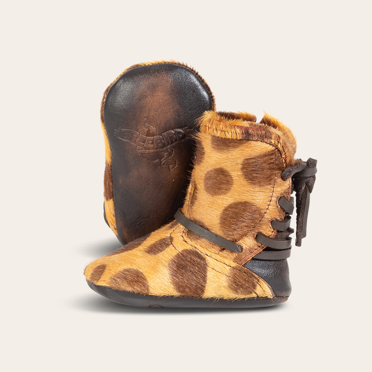 front view showing contrasting leather lace detailing and soft leather imprinted sole on FREEBIRD infant baby coal leopard leather bootie