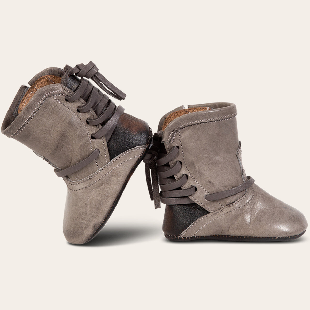 side view showing contrasting back lace detailing on FREEBIRD infant baby coal stone leather bootie 
