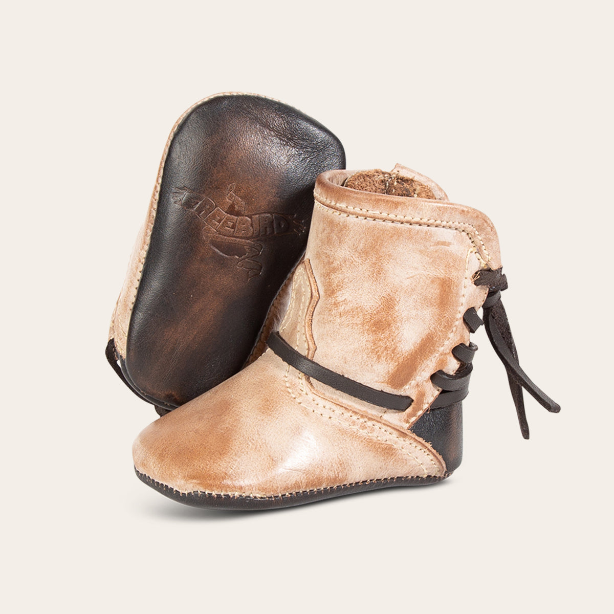 front view showing contrasting leather lace detailing and soft leather imprinted sole on FREEBIRD infant baby coal taupe leather bootie 