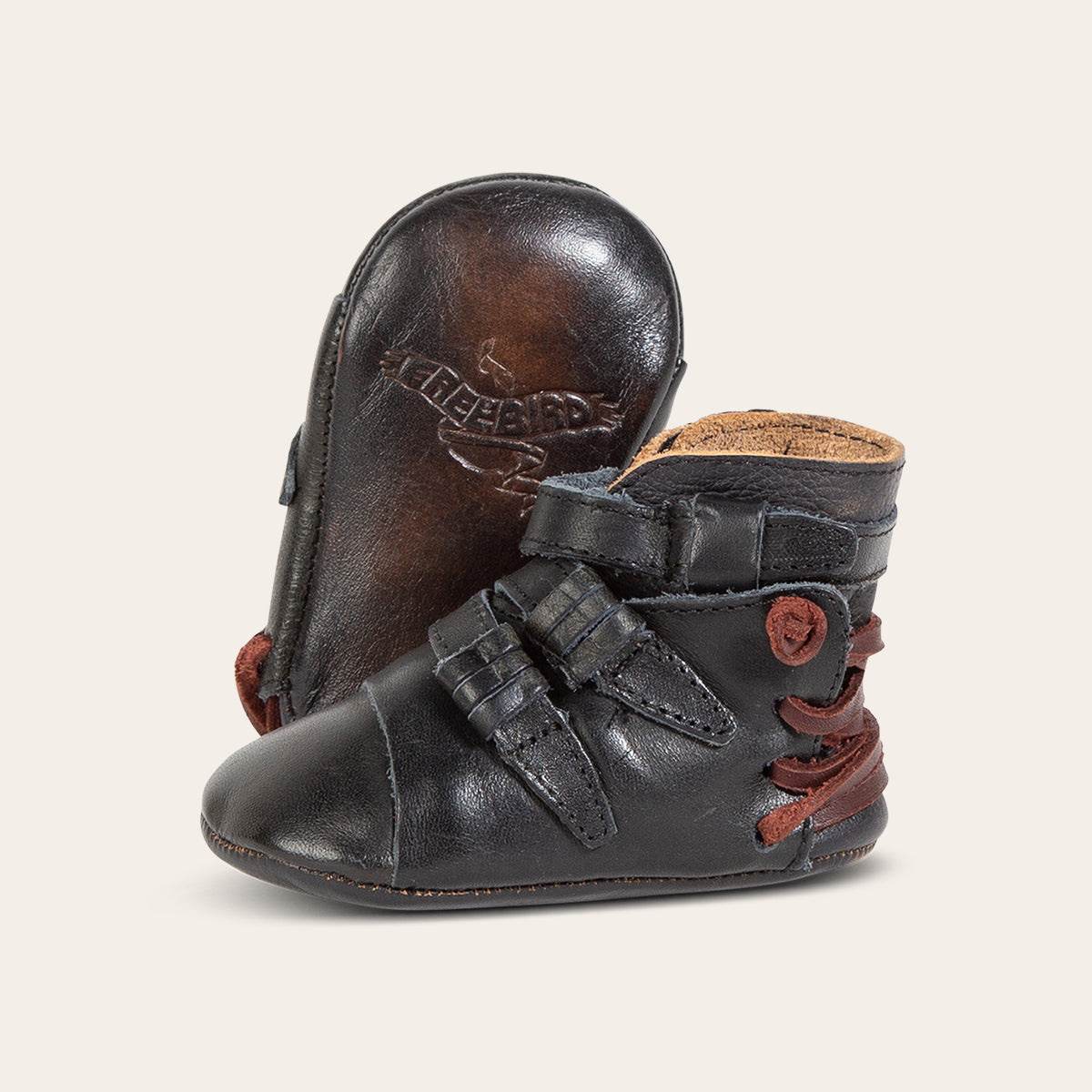 front view showing contrasting leather side strap detailing and soft leather imprinted sole on FREEBIRD infant baby crue black multi leather bootie