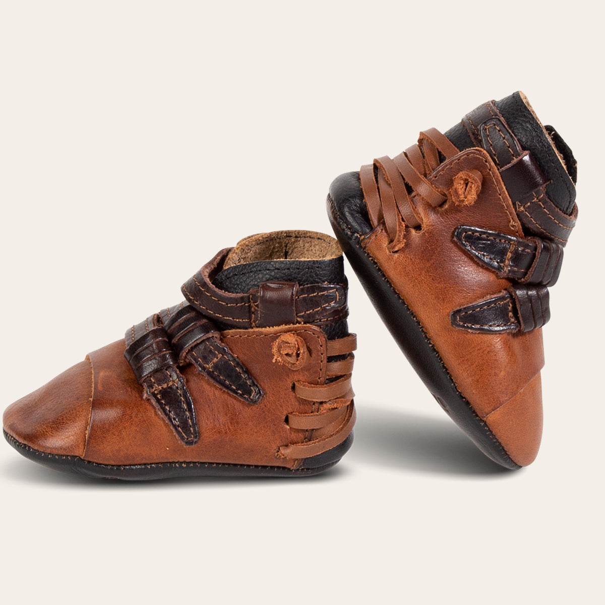 side view showing contrasting back lace and side strap detailing on FREEBIRD infant baby crue cognac leather bootie