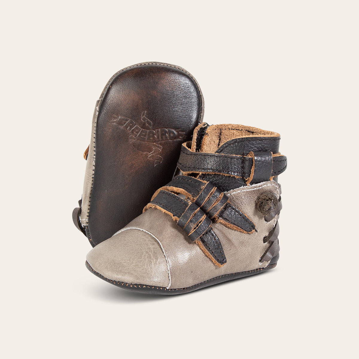 front view showing contrasting leather side strap detailing and soft leather imprinted sole on FREEBIRD infant baby crue grey multi leather bootie