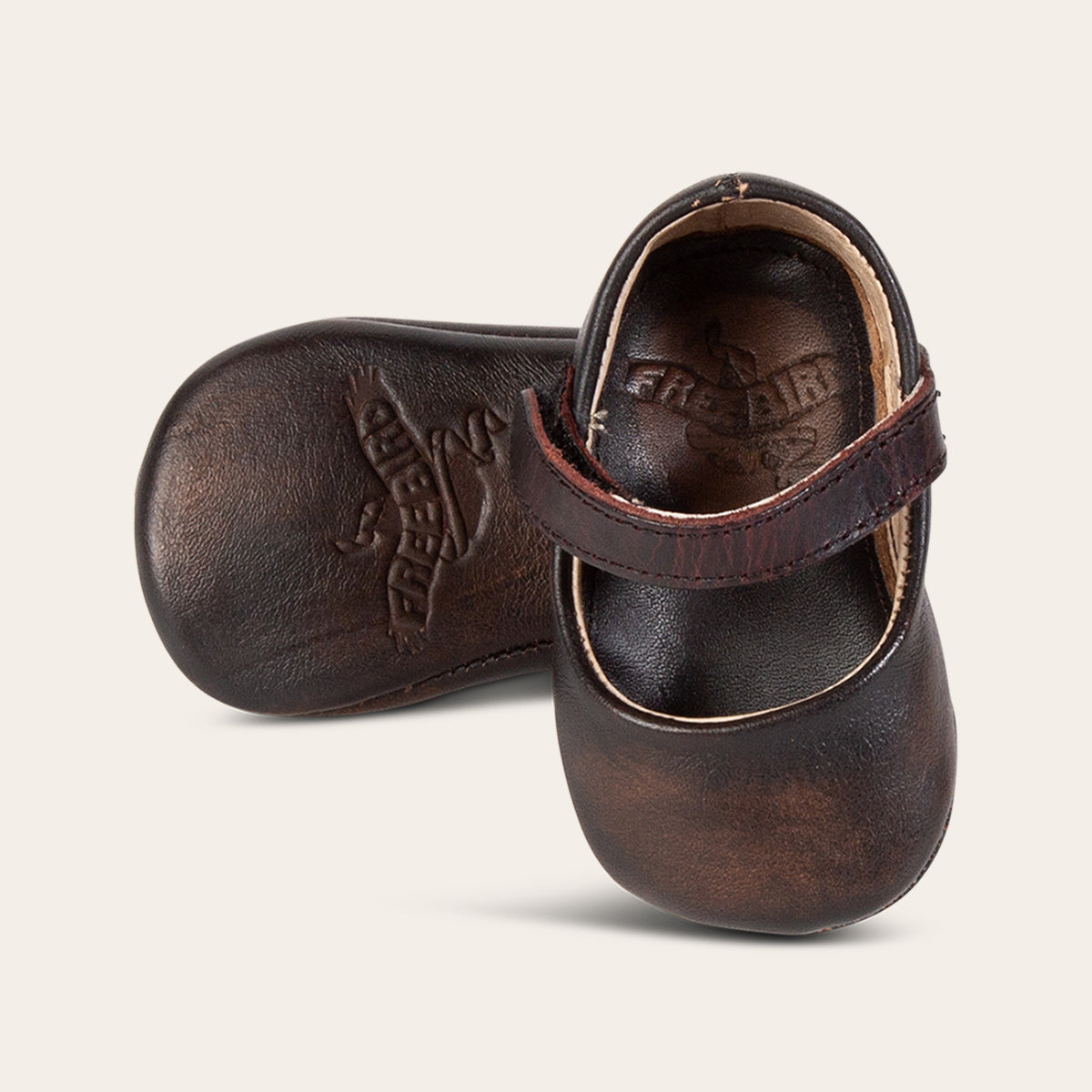 front view showing top leather strap and soft leather imprinted sole on FREEBIRD infant baby jane black distressed leather shoe