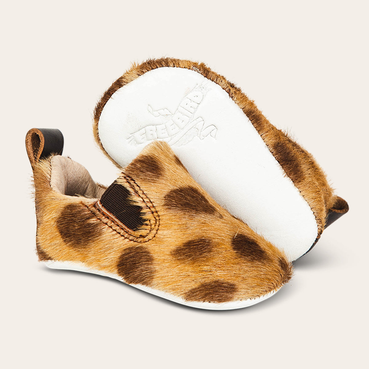 side view showing pull tab and side elastic panel and soft leather imprinted sole on FREEBIRD infant baby kicks leopard shoe