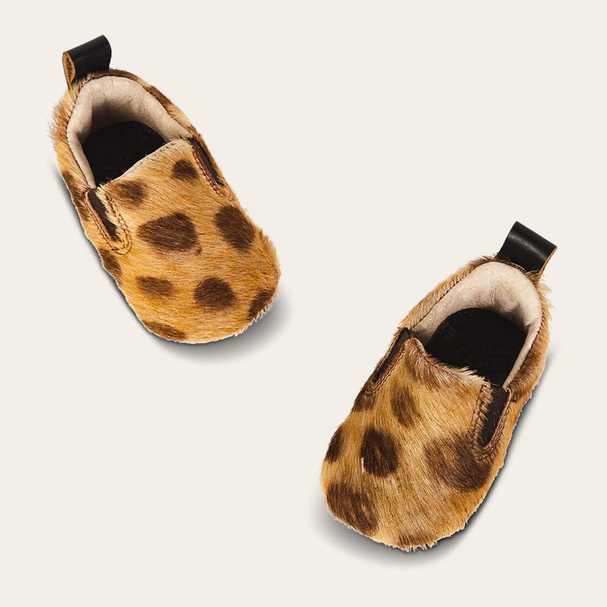top view showing heel pull tab and side elastic panel on FREEBIRD infant baby kicks leopard leather shoe