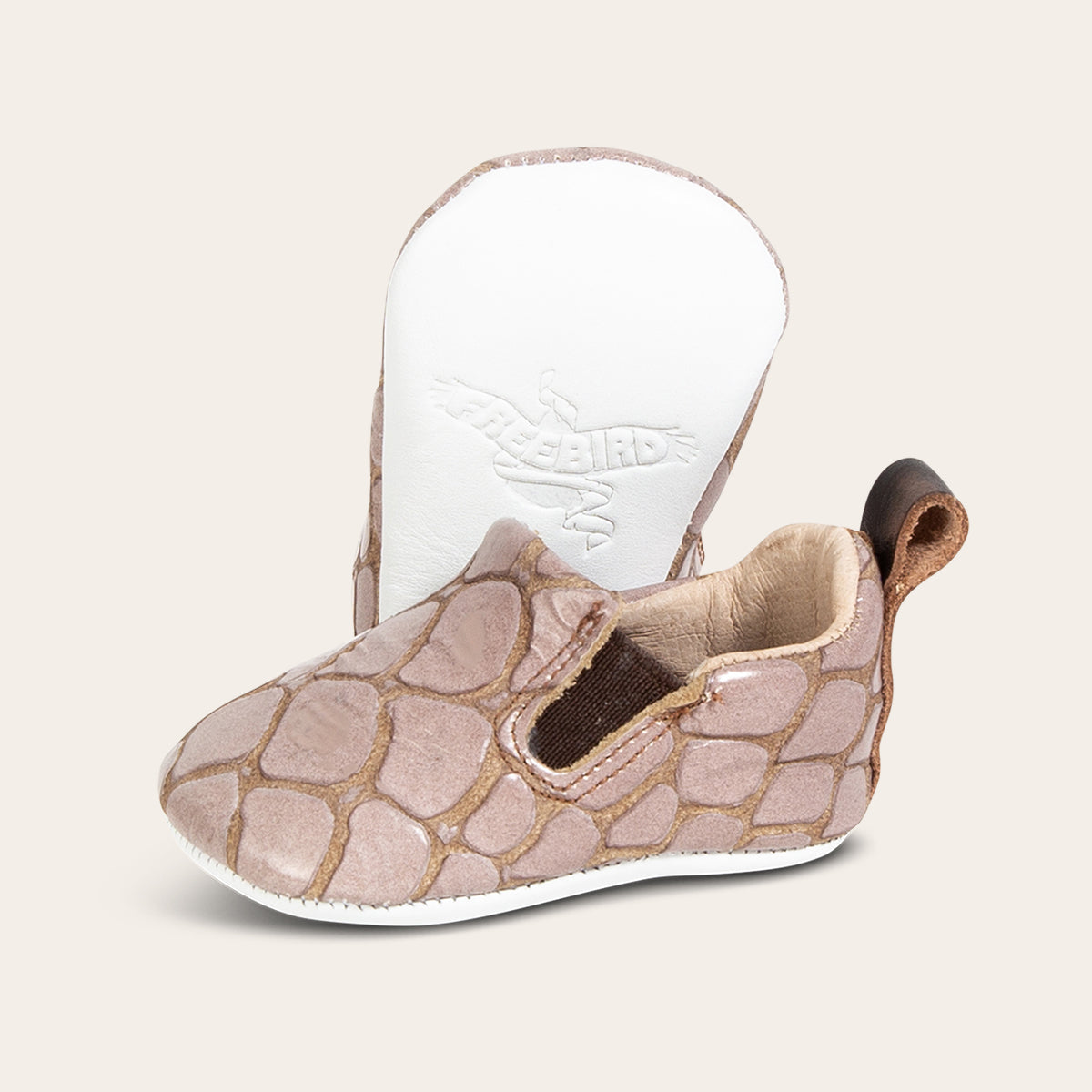front view showing pull tab and side elastic panel and soft leather imprinted sole on FREEBIRD infant baby kicks stone croco leather shoe