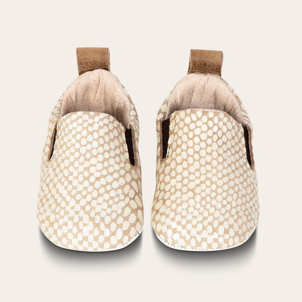 front view showing heel pull tab and side elastic panel on FREEBIRD infant baby kicks white snake leather shoe