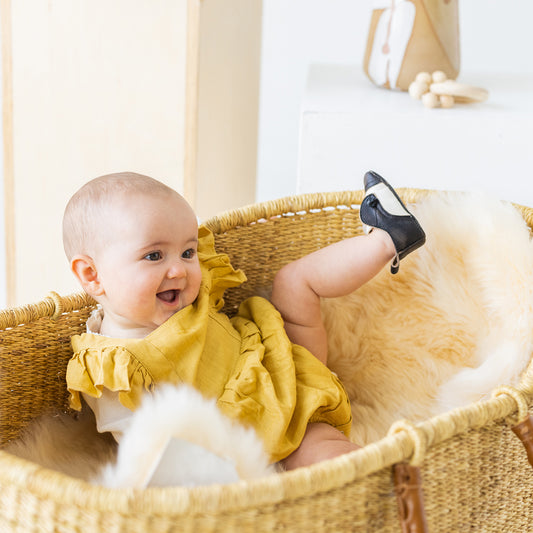 FREEBIRD infant baby Mabel black white leather shoe with decorative knotted leather lace and hidden inside elastic panel lifestyle image