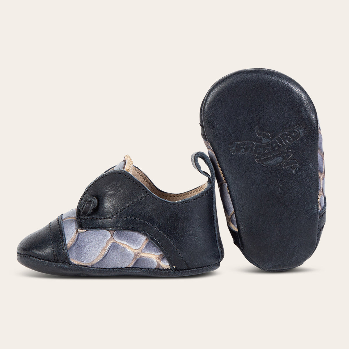 Side view showing decorative knotted leather lace and soft leather imprinted sole on FREEBIRD infant baby Mabel navy multi leather shoe