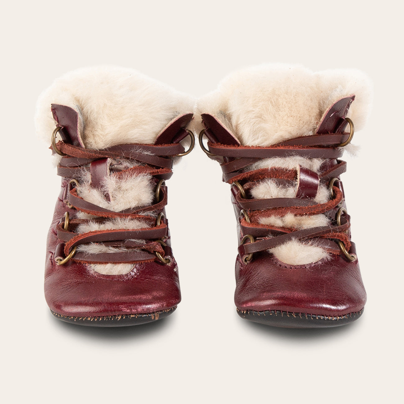 front view showing shearling lining and contrasting leather lace detailing on FREEBIRD infant baby Norway wine leather bootie