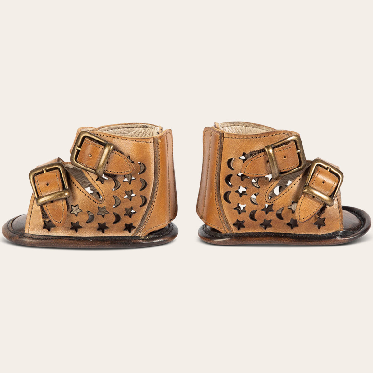 side view showing laser-cut leather, embossed fashion straps, back velcro panel on FREEBIRD infant baby teresa tan leather sandal